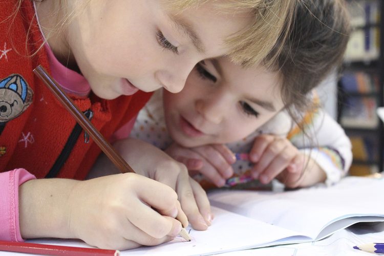 girls-on-desk-looking-at-notebook-web copy